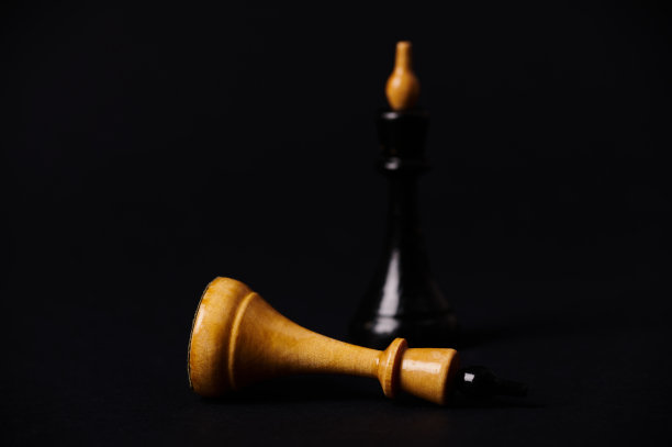 黑棋赢将死。黑王击败白王在棋局中孤立在黑色背景的侧视图图片下载