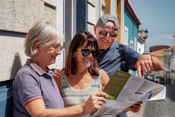 一群快乐的老人一边看地图，一边享受着阳光明媚的休闲旅行图片下载