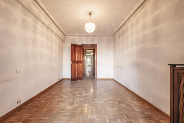 房子里的一个空房间，铺着风化的拼花木地板，还有暖气片盖图片下载