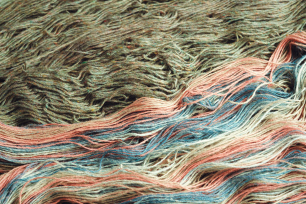 线来自天然有机羊毛。两束未缠绕的绿色和彩虹针织纱。图片下载
