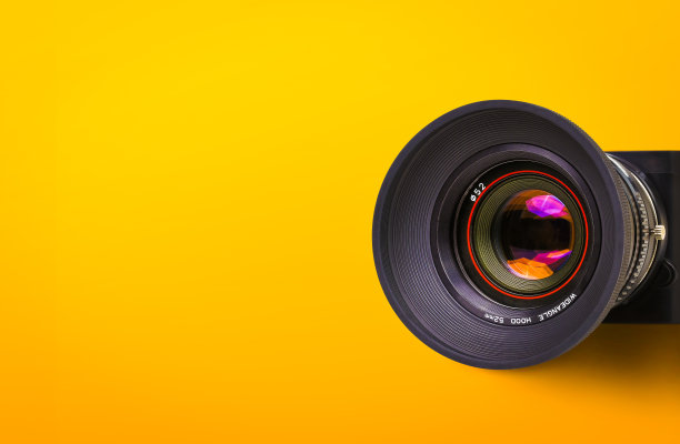 老式胶片相机的前镜头，黑色机身孤立在黄色或橙色背景上图片下载