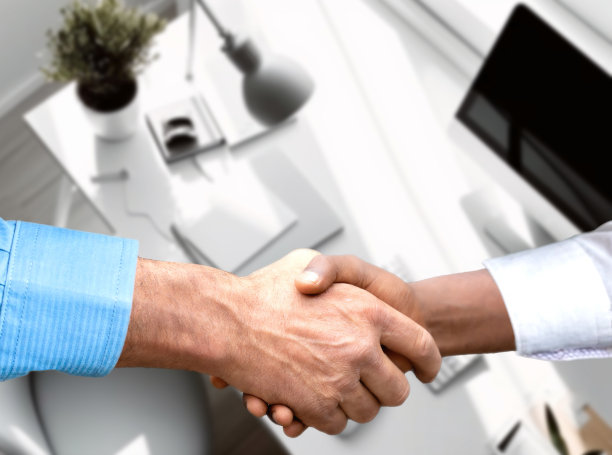 近距离观察商业伙伴握手的概念。两位商人握手过程的照片。伟大的会议后成功的交易。水平，耀斑效果，模糊的背景与团队办公室。出色的团队合作，工作面试图片下载