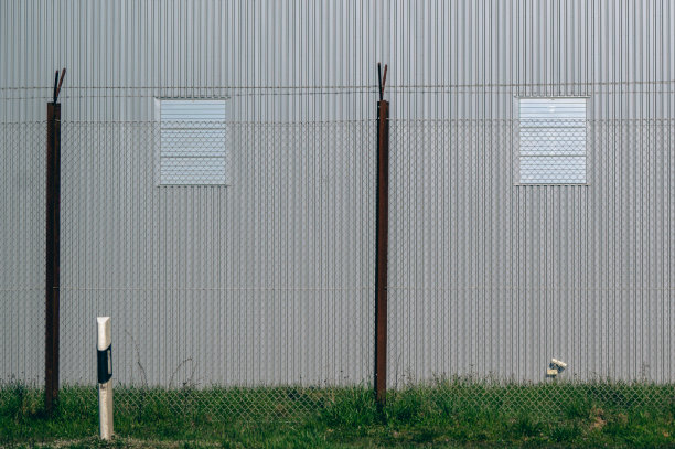 大仓库前草坪上的防护栅栏图片下载