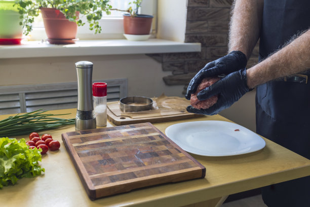 一个人在桌边做汉堡肉饼，特写图片下载