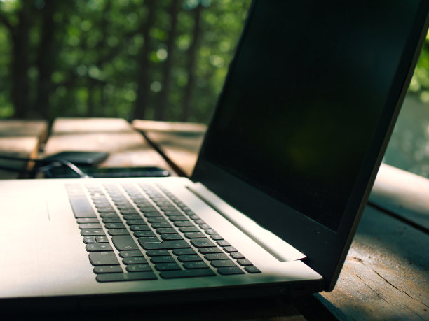 笔记本电脑放在户外的木桌上图片下载