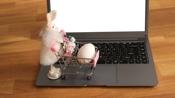 一个玩具兔子和一个杂货篮子，笔记本电脑键盘上有一个鸡蛋。图片下载