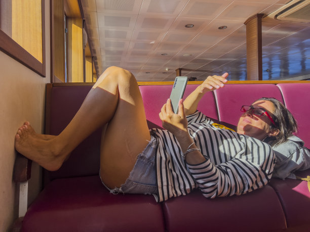 女人仰面躺着，看手机。图片下载