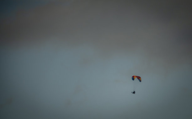 波希米亚北部春天清新的天空中，骑着自行车和降落伞的男子图片下载