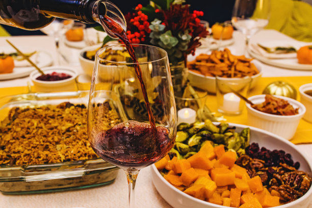 红酒倒进酒杯，站在感恩节宴会桌上，图片下载