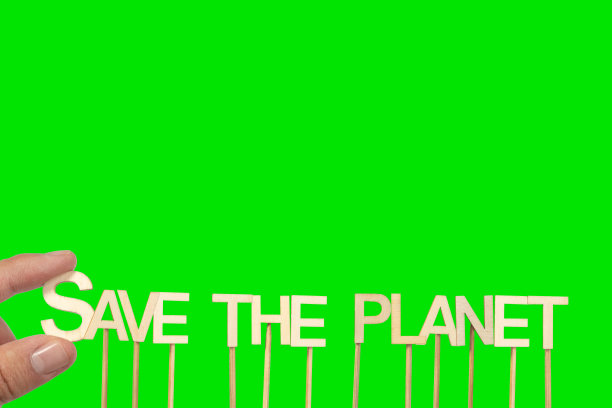 一个人用绿色色度背景上的单个木制字母制作“拯救地球”标志。图片下载