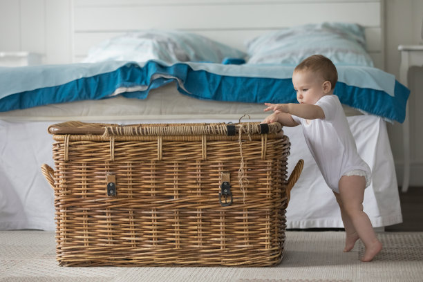 好奇可爱的婴儿穿着白色的紧身衣学习站立图片下载