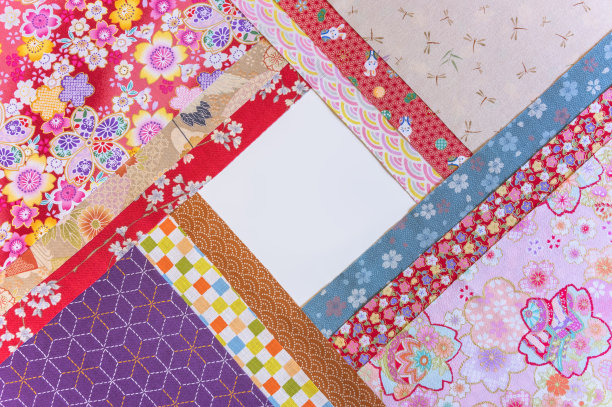 叠成菱形或菱形的摊开织物，上面有传统的日本几何图案、花卉、动物或昆虫图案。图片下载