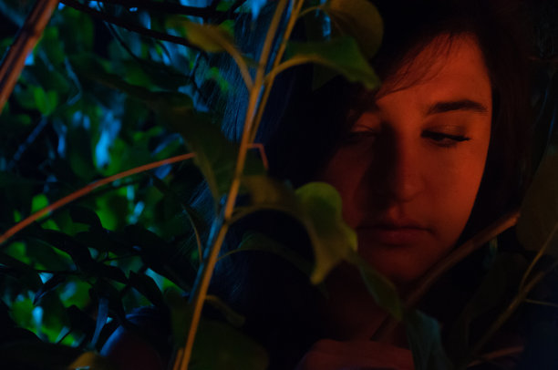 一个女人在夜晚的丛林里，在月光和篝火的照耀下的特写图片下载