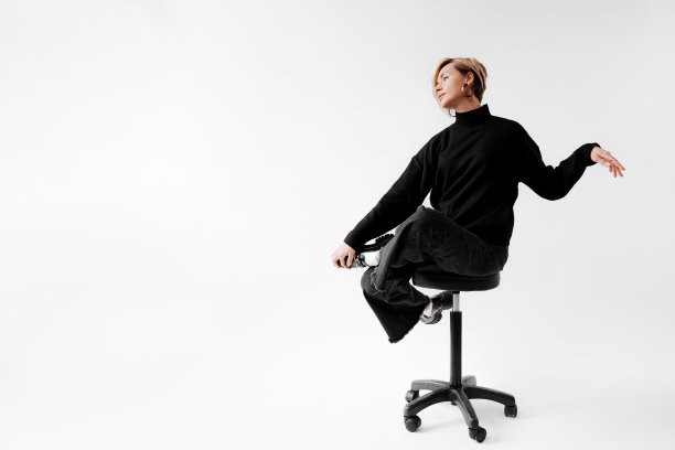 时髦的金发女人坐在椅子上图片下载