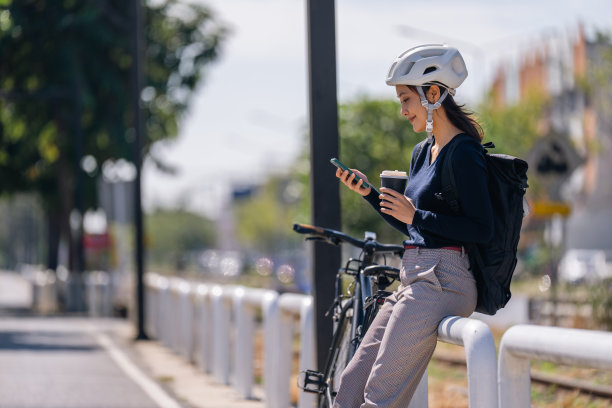 亚洲女性骑车上班天气好的时候，她会在路上休息一下，喝杯咖啡。图片下载
