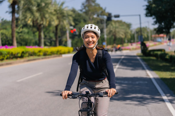 亚洲女性在好天气骑自行车上班图片下载