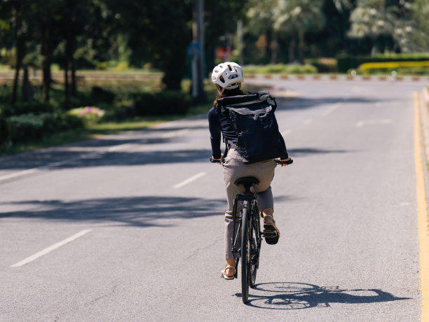 亚洲女性在好天气骑自行车上班图片下载