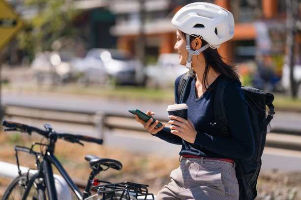 亚洲女性骑车上班天气好的时候，她会在路上休息一下，喝杯咖啡。图片下载