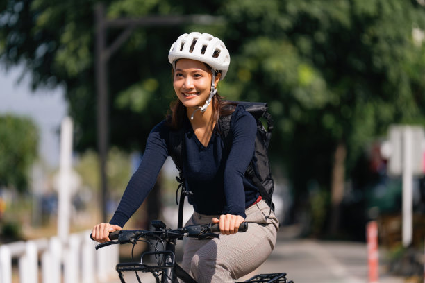 亚洲女性在好天气骑自行车上班图片下载