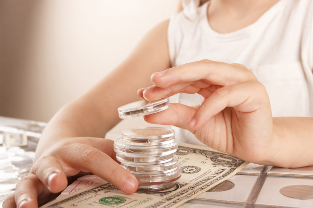 孩子拿着不同的硬币和钞票图片下载