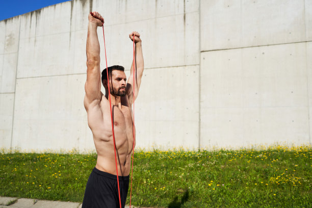 运动男子在户外运动，带着阻力健身手环图片下载