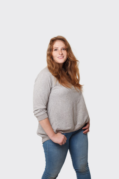 快乐、积极、曲线美的女人，红色的长发站在白色的背景上图片下载