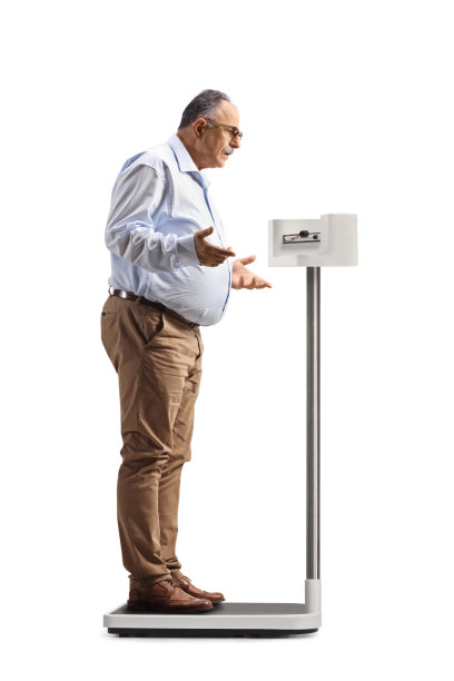 站在体重秤上用手势比划的惊讶中年男子全身照图片下载