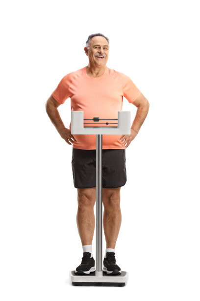 一位肥胖的成熟男人站在医用体重秤上的全身像图片下载