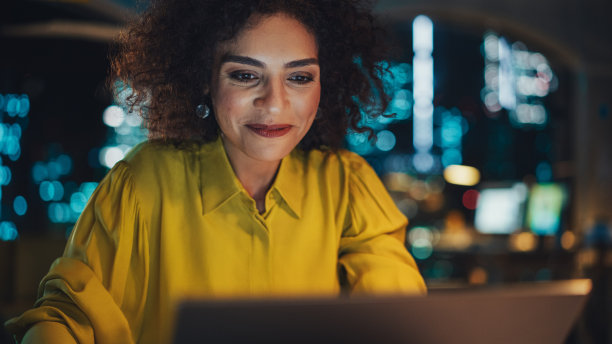 一个有创意的多民族女性在办公室用笔记本电脑工作的特写肖像。快乐驱动项目经理撰写创意简报，为客户制定营销策略。图片下载