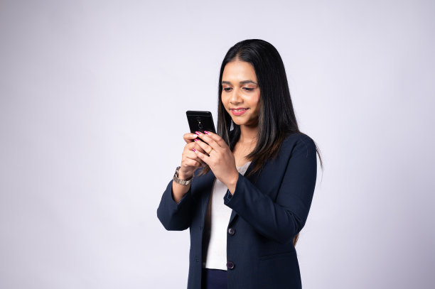 年轻女子使用智能手机，工作室拍摄的白色背景图片下载