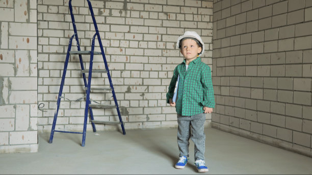 一个戴着白色头盔的小男孩手里拿着文件图片下载