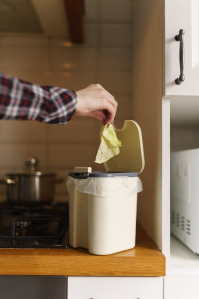 女性用手将可堆肥的剩饭剩菜扔进装有堆肥的bokashi容器图片下载