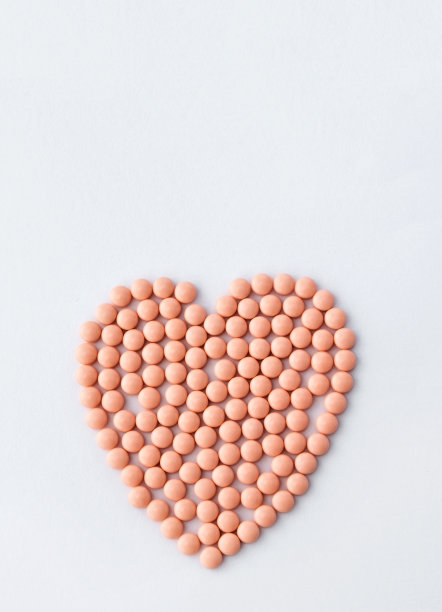 白色背景上心形的粉色药丸。维生素和健康皮肤的补品。网上药店。制药行业。爱的治疗方法。高质量的照片。图片下载