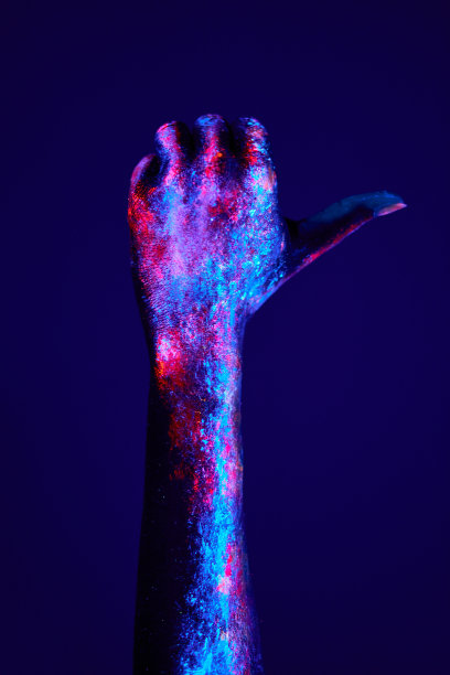 特写女性的手与荧光画在霓虹大胆的颜色，显示在一边。图片下载