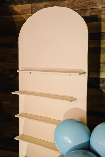 墙上有架子，用来放给男孩的礼物。派对上用蓝气球做的生日装饰。部分拱门和照片墙庆祝儿童活动。文本的空间或位置。特写镜头。图片下载