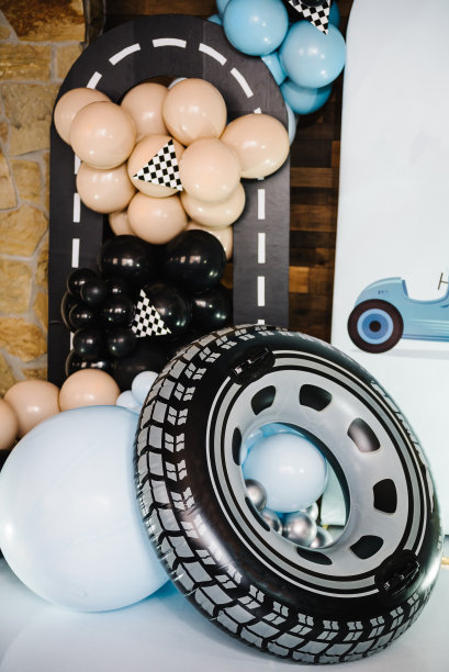 时髦的装饰有旗帜，赛车，轮子，男孩的车。生日装饰用蓝色，棕色，黑色，银色气球为聚会。庆祝活动的拱门。有文字空间或地方的照片墙。特写镜头。图片下载