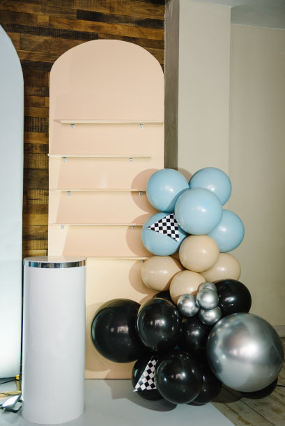 时髦的装饰，带着赛车旗，给男孩开的车。生日装饰用蓝色，棕色，黑色，银色气球为聚会。庆祝活动的拱门。有文字空间或地方的照片墙。放蛋糕的桌子。图片下载