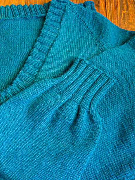 手工编织产品。汽油色的彩色线编织织物。棕色的背景。图片下载