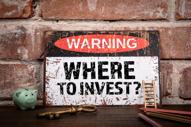 在哪里投资。木制办公桌上的文字警告标志图片下载