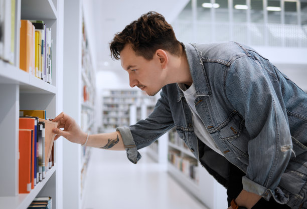 图书馆搜索，大学生和男子寻找大学，教育和知识书籍。大学，学生和书架上的书学习，学习和学术信息的校园图片下载