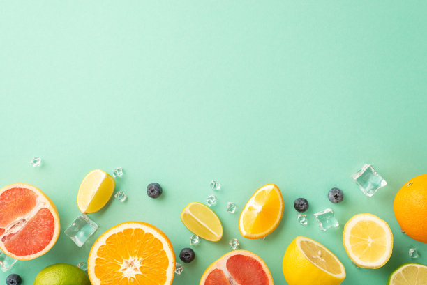 柑橘爆炸概念。蓝绿色背景上的新鲜橙子、柠檬、酸橙和葡萄柚，配以薄荷叶的俯视图，空白空间为宣传文字图片下载
