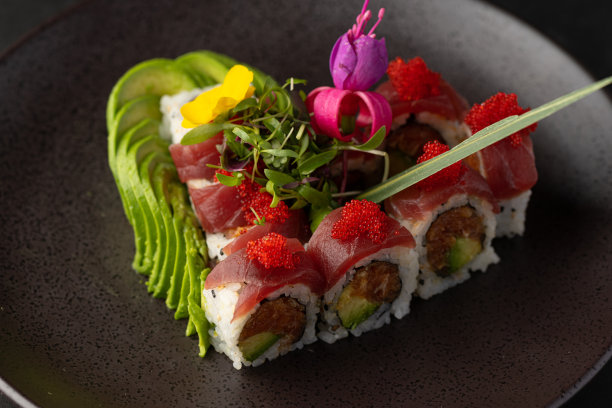 各种各样的日本菜，用新鲜的鱼和新鲜的食材装饰精美，灯光突出了日本料理的鲜艳色彩和纹理图片下载