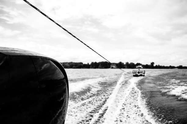 在一项被称为油管的娱乐活动中，橡皮艇被一艘船高速拉着图片下载