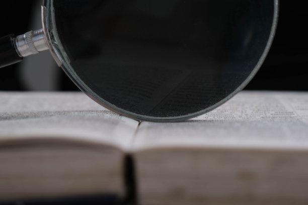 放大镜放在桌上打开的书上。教育和研究理念。图片下载