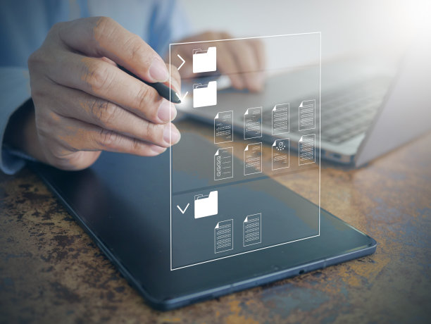 一位商人在笔记本电脑上使用文档管理系统(DMS):用于高效企业文件归档、搜索和管理的办公软件图片下载