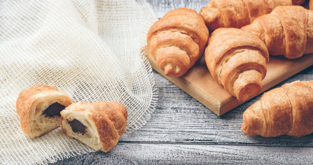 羊角面包的特写镜头。美味的新鲜热糕点。新鲜出炉的牛角面包。温暖的新鲜黄油牛角面包。咖啡。图片下载