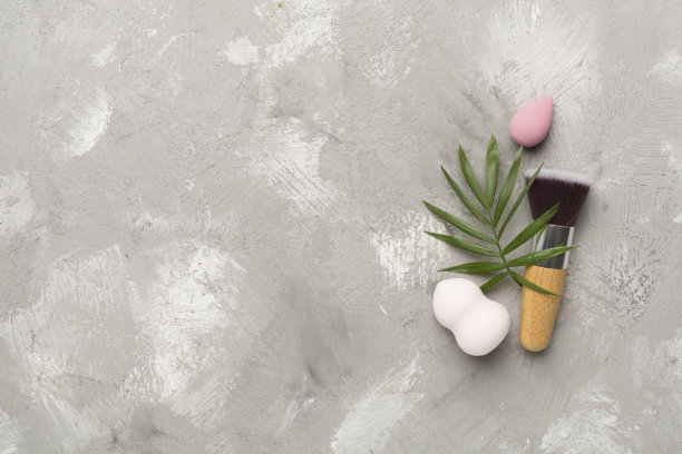 在混凝土背景上化妆刷和海绵，俯视图图片下载