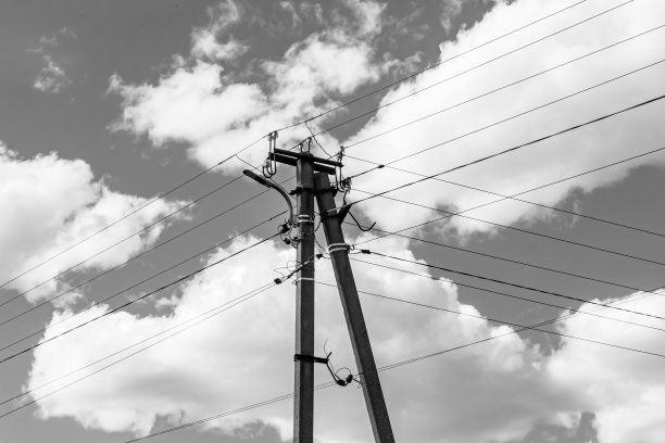 光背景上有电线的动力电线杆近景图片下载