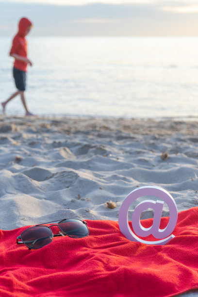 海滩上的电子邮件标志和海滩上散步的孩子图片下载