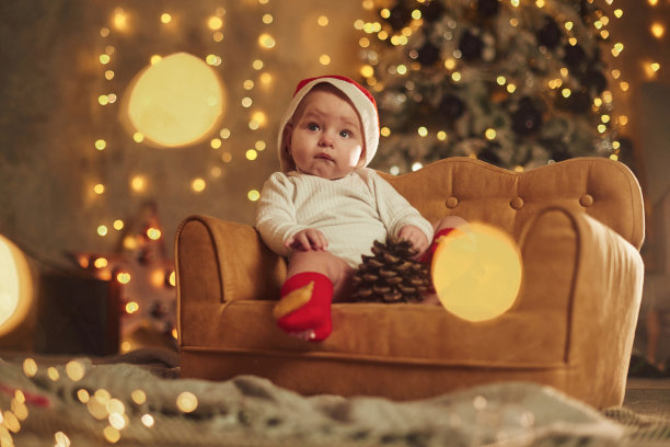 在可爱的小沙发上。宝宝在家。新年装饰。假期的概念图片下载